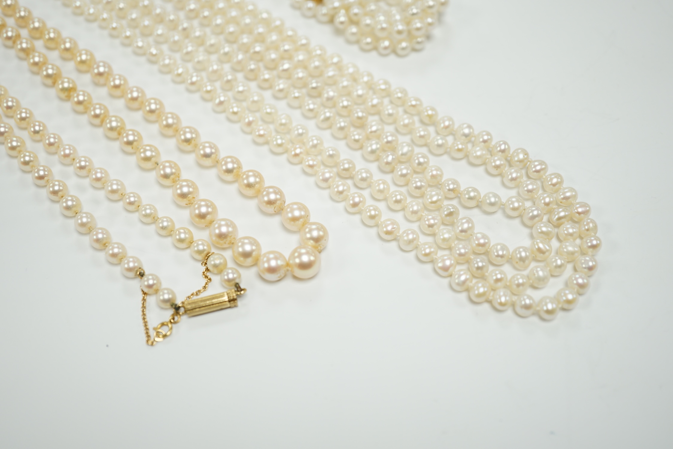 Two Cultured pearl necklaces including a triple strand with yellow metal and sapphire set clasp, 46cm and a matching bracelet.